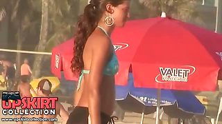 The turning on brunette on the beach is wearing the sport