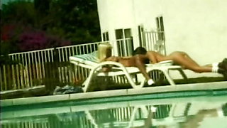 Perfect lesbo babes with fake boobs sharing a dildo by the pool