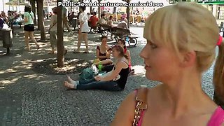 Sexy girl shows tits in the middle of a lively square