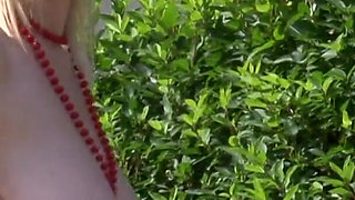 Superb blonde babe with huge boobs is showing her an amazing body outdoors