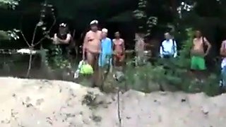 Slutty blonde surrounded by cocks at the beach