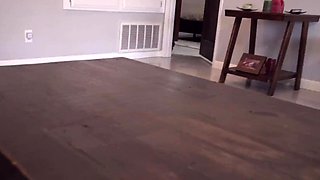 In a kitchen a sexy brunette playing with her big boobs
