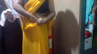 Indian housewife is wearing a yellow saree.