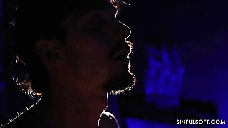 Gatita Veve kisses a bearded man under violet light