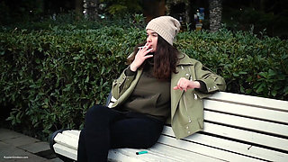 Young Brunette Is Taking an Unhurried Stroll with Allwhite 120mm Cigarette
